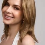 Beautiful woman with shoulder-length blonde wig, smiling and looking at the camera.